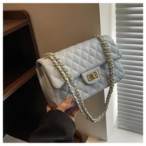 Close-up of light blue quilted leather bag with gold chain strap and turn-lock