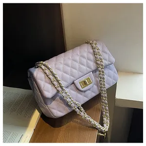 Macro view of light purple quilted handbag with gold lock and textured leather detail