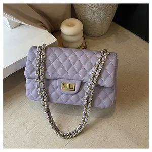 Detailed macro view of light purple quilted leather bag texture with gold chain strap