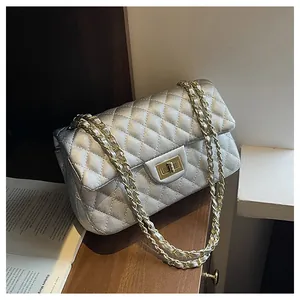 Close-up of silver quilted shoulder bag with gold twist lock and chain strap