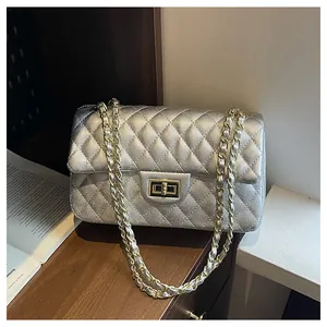 Detail of silver quilted leather handbag with gold turn-lock and chain strap