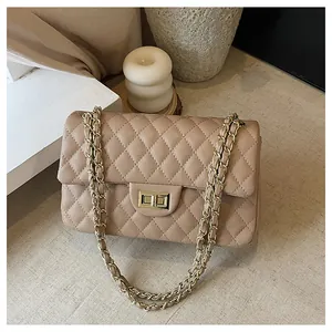 Detail of beige quilted shoulder bag with classic lattice stitching and gold chain