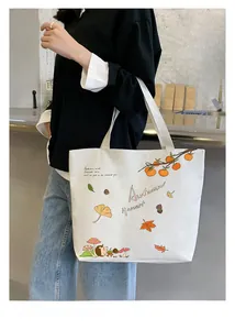 Detail view of white canvas tote bag with autumn hedgehog and maple leaf illustrations