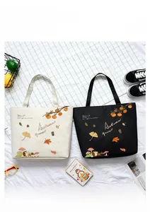 Detail of canvas tote bags with autumn harvest pumpkin and hedgehog illustrations