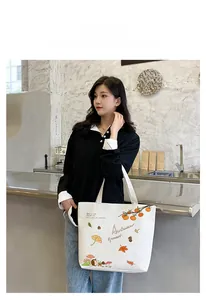 Detail of white canvas tote bag with autumn illustration and wide shoulder straps