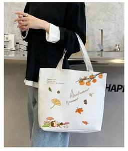 Detail of white canvas tote bag featuring autumn harvest hedgehog and maple leaf print