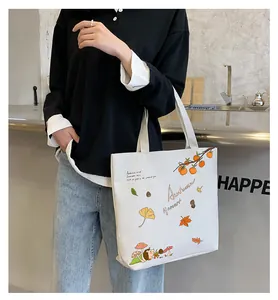 Detail of canvas tote bag with autumn illustration of persimmons and gingko leaves