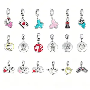 Assorted stainless steel charms including heart, butterfly and logo pendants on white background