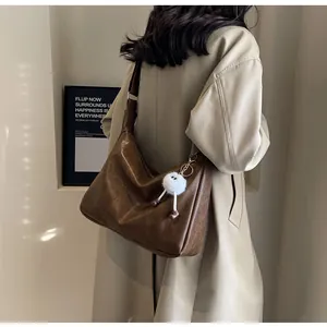 Detailed view of the dark brown oversized soft faux leather crescent crossbody bag