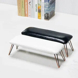 Close-up of black and white leather nail arm rests with elegant rose gold metal legs