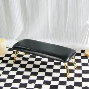 Close-up of black leather nail armrest stool with elegant gold metal legs on a checkered rug