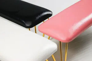 Three minimalist nail armrests in black, pink, and white with golden hairpin legs