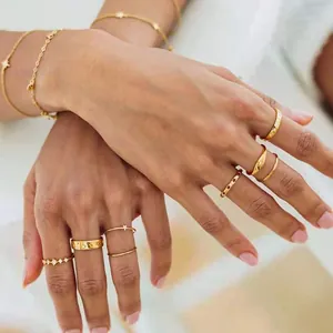 Detail of 18k gold plated hollow star rings and bracelet set worn on hand