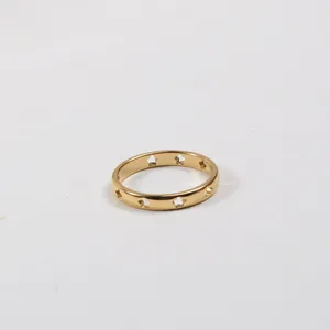 Detail of 18k gold plated stainless steel ring with hollowed out star pattern and glossy finish
