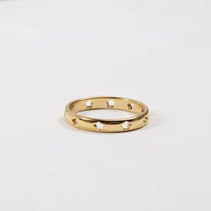 Macro detail of gold plated titanium steel ring with hollowed out star patterns