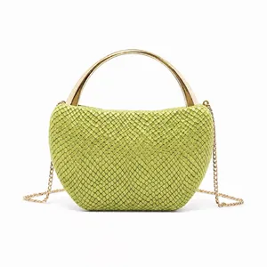 Close-up of green snake pattern evening bag with golden ring handle and chain strap