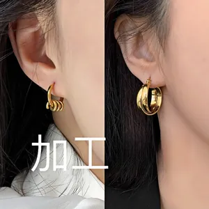 Close-up of dual-style gold geometric hoop earrings showing polished finish and textures