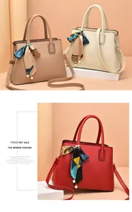 Detail of luxury textured handbags in beige and brown with silk scarf and pearl charms
