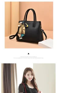 Detail of black leather handbag with chic colorful silk scarf and pearl pendant accents