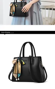 Classic black handbag detail with a patterned silk scarf and pearl pendant ornament