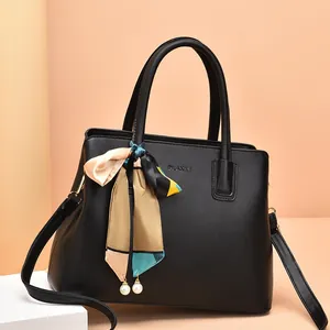 Elegant black leather handbag for women featuring a printed scarf and pearl charm detail