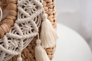 Detailed close-up of straw woven bag with white bohemian tassels and crochet lace