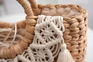 Detail of hand-woven straw bag with bohemian macramé patterns and silk drawstring lining