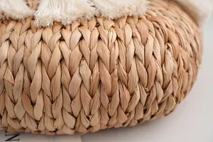 Close-up of handmade straw woven bag texture with elegant white tassel detail