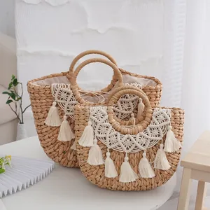 Detailed close-up of straw woven tote bags with bohemian white lace and tassels