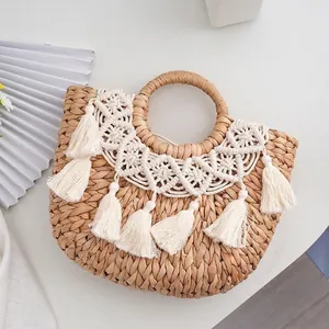 Handmade straw woven handbag with white tassel fringe in a bohemian summer beach style