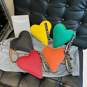 Macro detail of heart-shaped leather bags with LOVE logo webbing handles in multiple colors