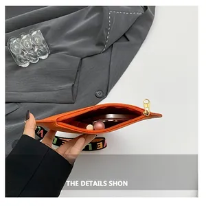 Detail of orange heart-zip handbag showing interior capacity for phone and cosmetics