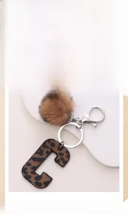 Close-up of leopard print letter C keychain with a soft brown faux fur pompom charm