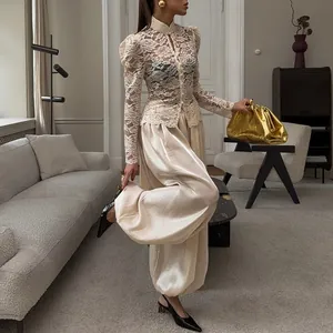 Pantaloni a lanterna in raso champagne lucido con silhouette fluida e vestibilità morbida