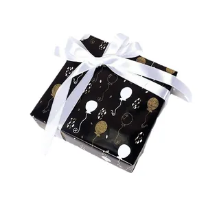 Elegant black gift box with gold balloon prints and a large white satin ribbon bow