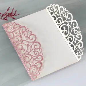 Detail of laser-cut wedding invitation with pink glitter floral hollow design