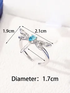 Macro shot showing dimensions of silver dragonfly ring with a blue gemstone and open band