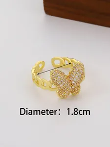 Macro shot of gold butterfly open ring with cubic zirconia and cuban chain design