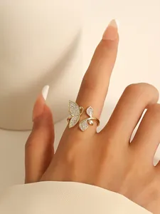 Close-up of golden butterfly open ring with sparkling zircon stones on finger