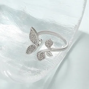 Macro shot of silver butterfly ring with sparkling crystals on a textured glass base