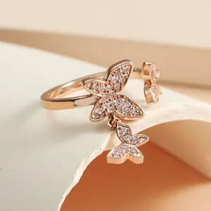 Macro detail of rose gold butterfly open ring with hanging zircon pendant design