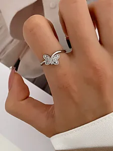 Detail of silver butterfly ring with sparkling zircons worn on the index finger