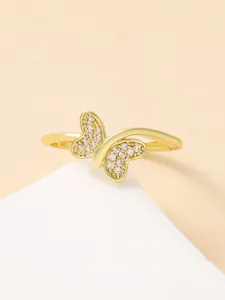 Detail of a gold butterfly ring featuring sparkling pavé crystals and polished band