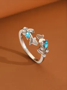 Macro detail of silver butterfly ring with blue marquise stones and zircon accents