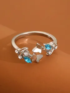Detailed close-up of butterfly ring with blue marquise gems and silver finish