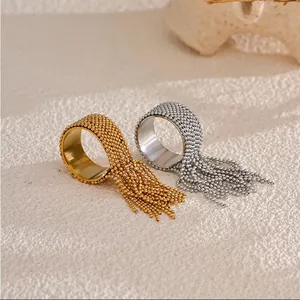 Elegant beaded tassel open rings in gold and silver finish on a natural stone surface