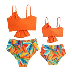 Set bikini coordinati madre e figlia con stampa a foglie tropicali su fondo bianco