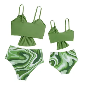 Dettaglio dei bikini coordinati madre e figlia verdi con slip a motivi a onde