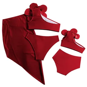 Detailed flat lay of a burgundy 3-piece bikini set with 3D floral accents and a matching sarong