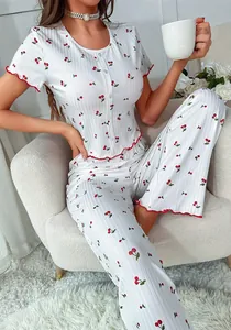 Detail of cherry print pajamas set showing lettuce edge trim and ribbed texture